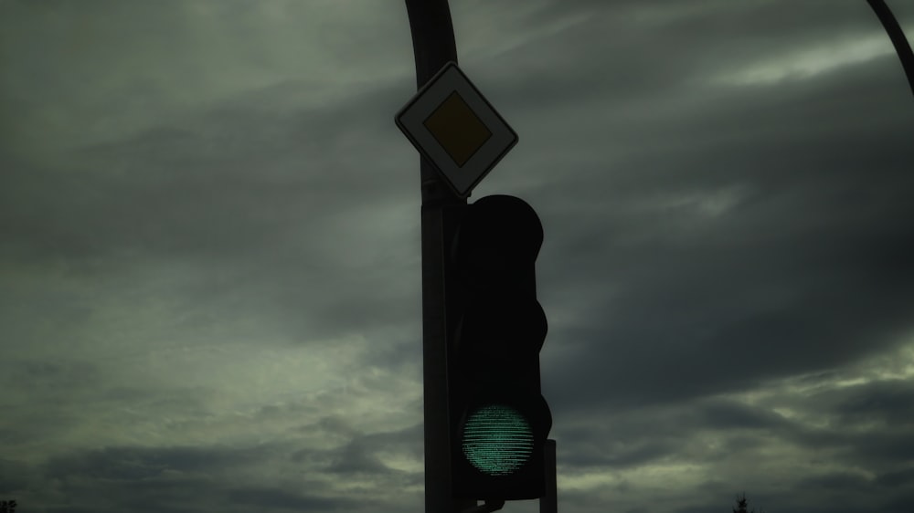 a traffic light with a cloudy sky in the background