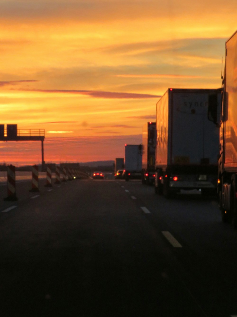 a semi truck driving down a highway at sunset