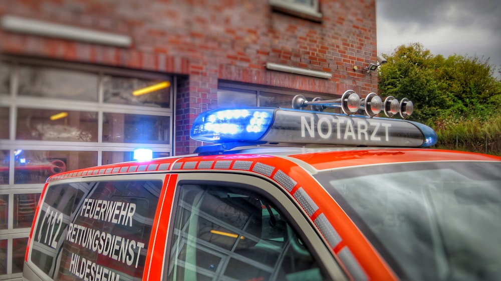 an orange police car parked in front of a building