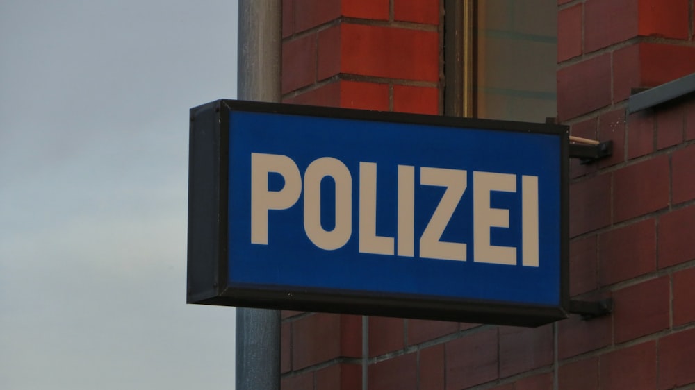 a close up of a street sign sitting on the side of a building