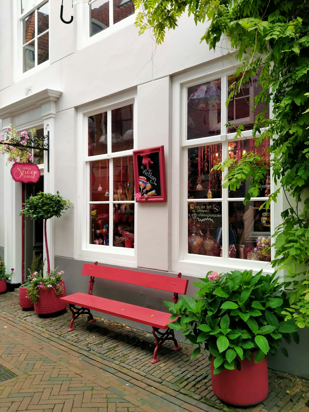 a red bench sitting in front of a white building