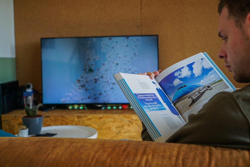 a man sitting on a couch reading a book