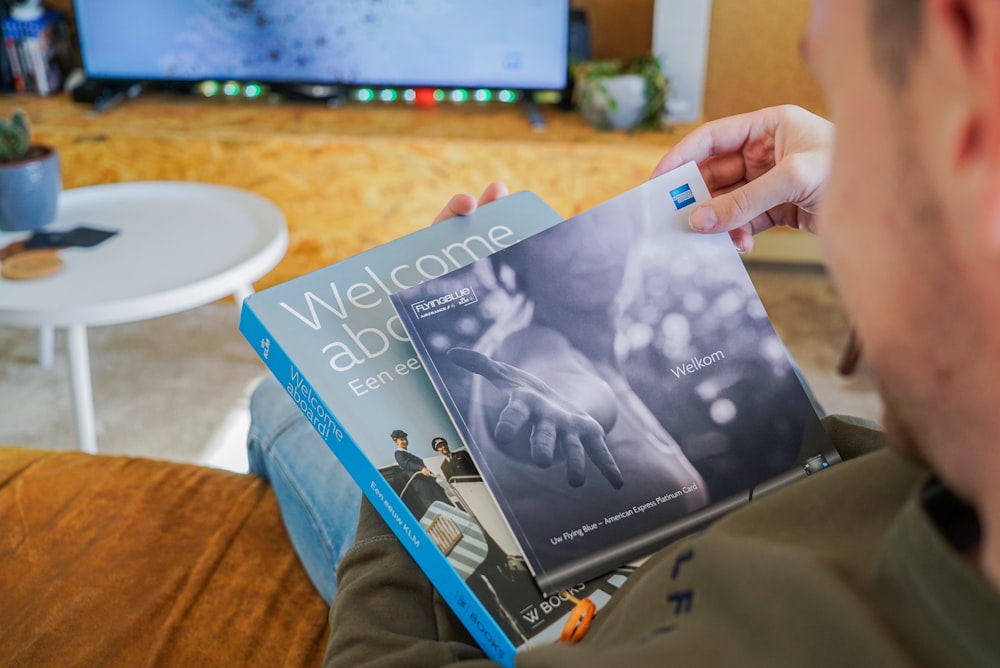 a man sitting on a couch holding a book