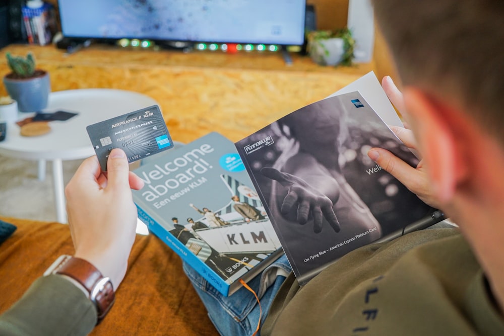 a man reading a book in front of a television