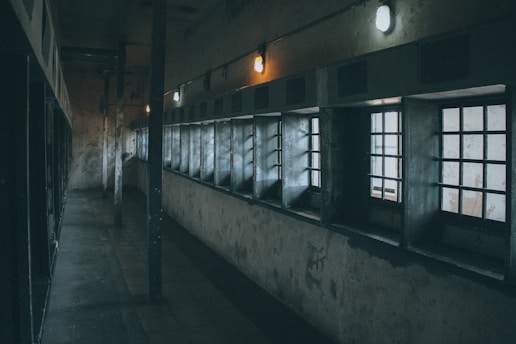 a dimly lit hallway with windows and bars