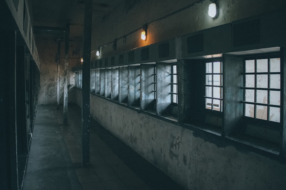 a dimly lit hallway with windows and bars