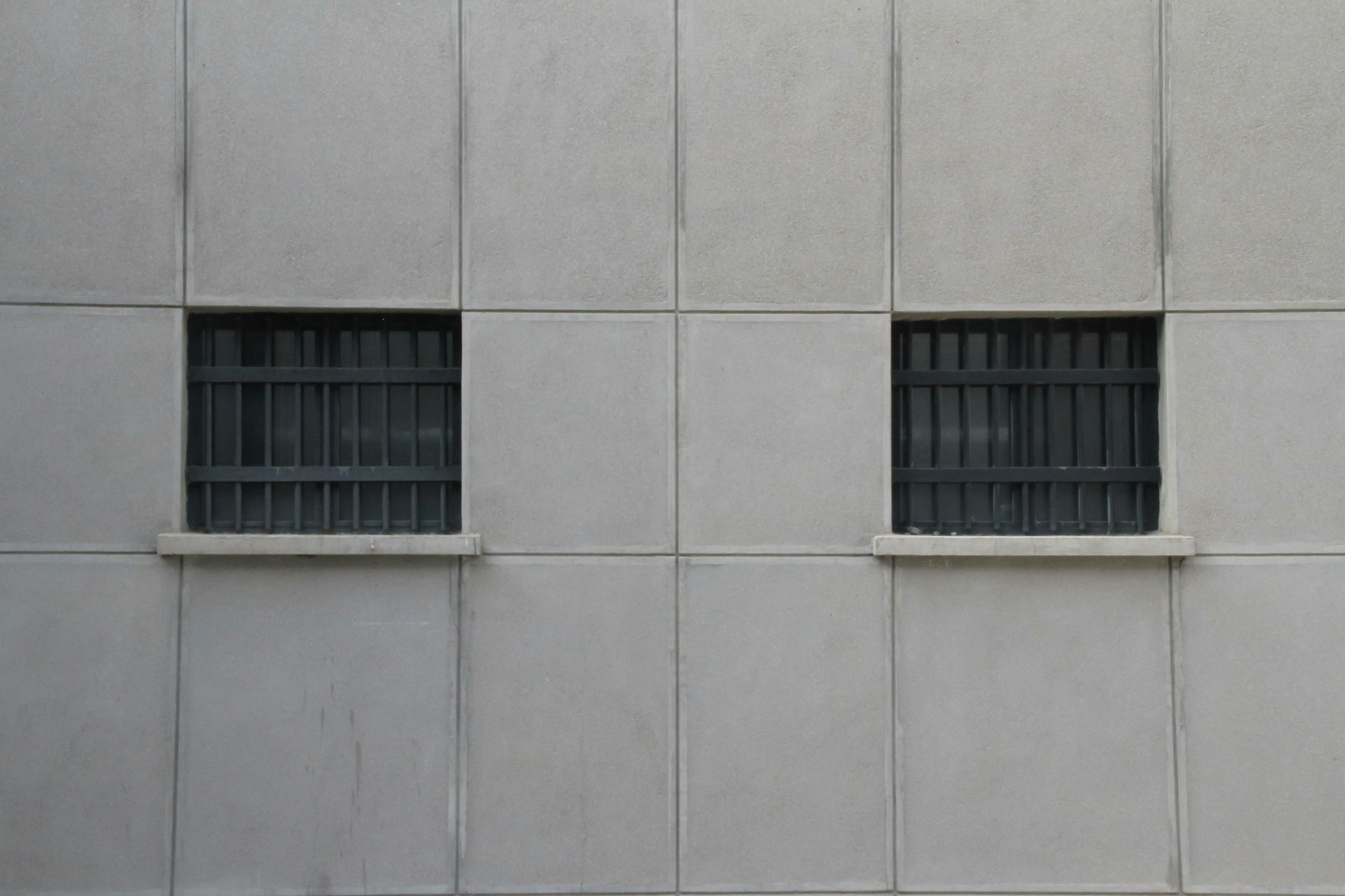 a building with two windows and bars on the side