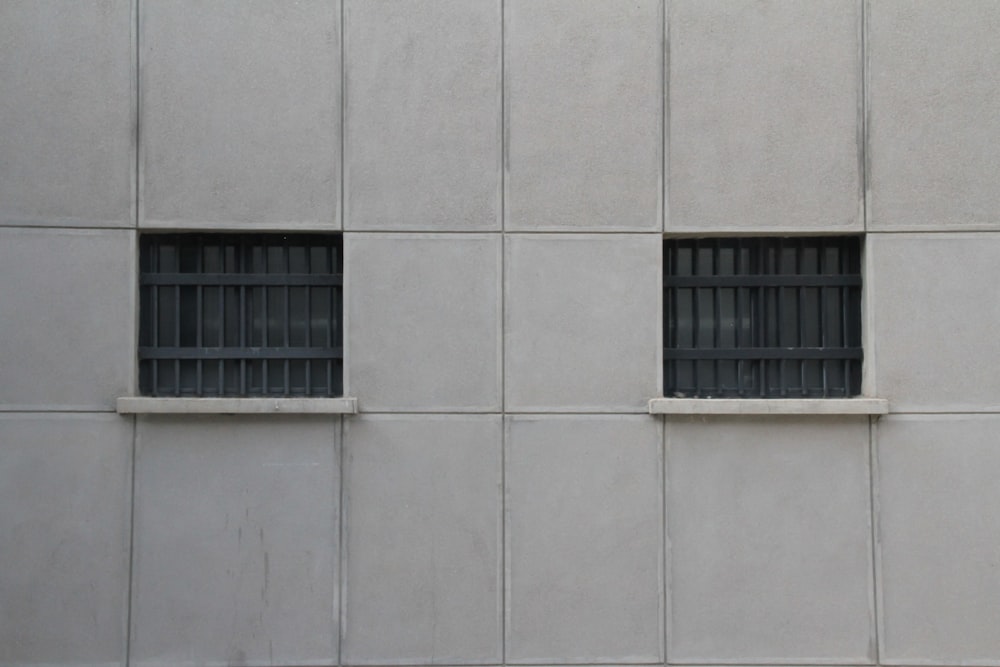 a building with two windows and bars on the side