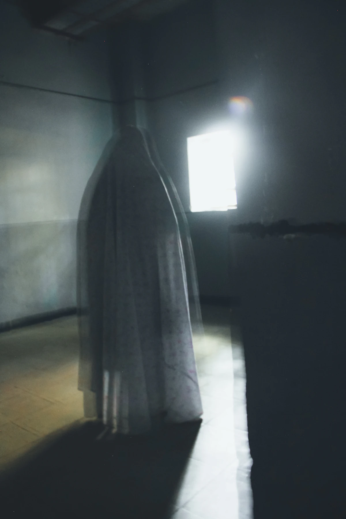 A blurred figure standing in a dark room