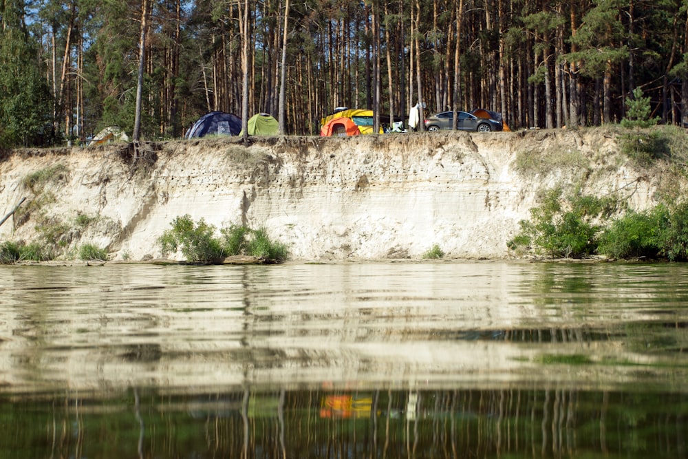 Eine Gruppe von Zelten, die auf einer Klippe neben einem Gewässer sitzen
