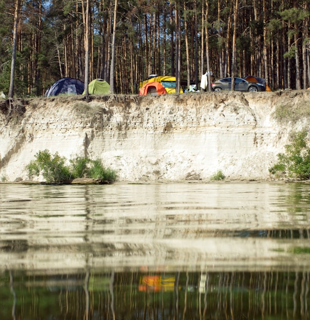 a group of tents sitting on top of a cliff next to a body of water