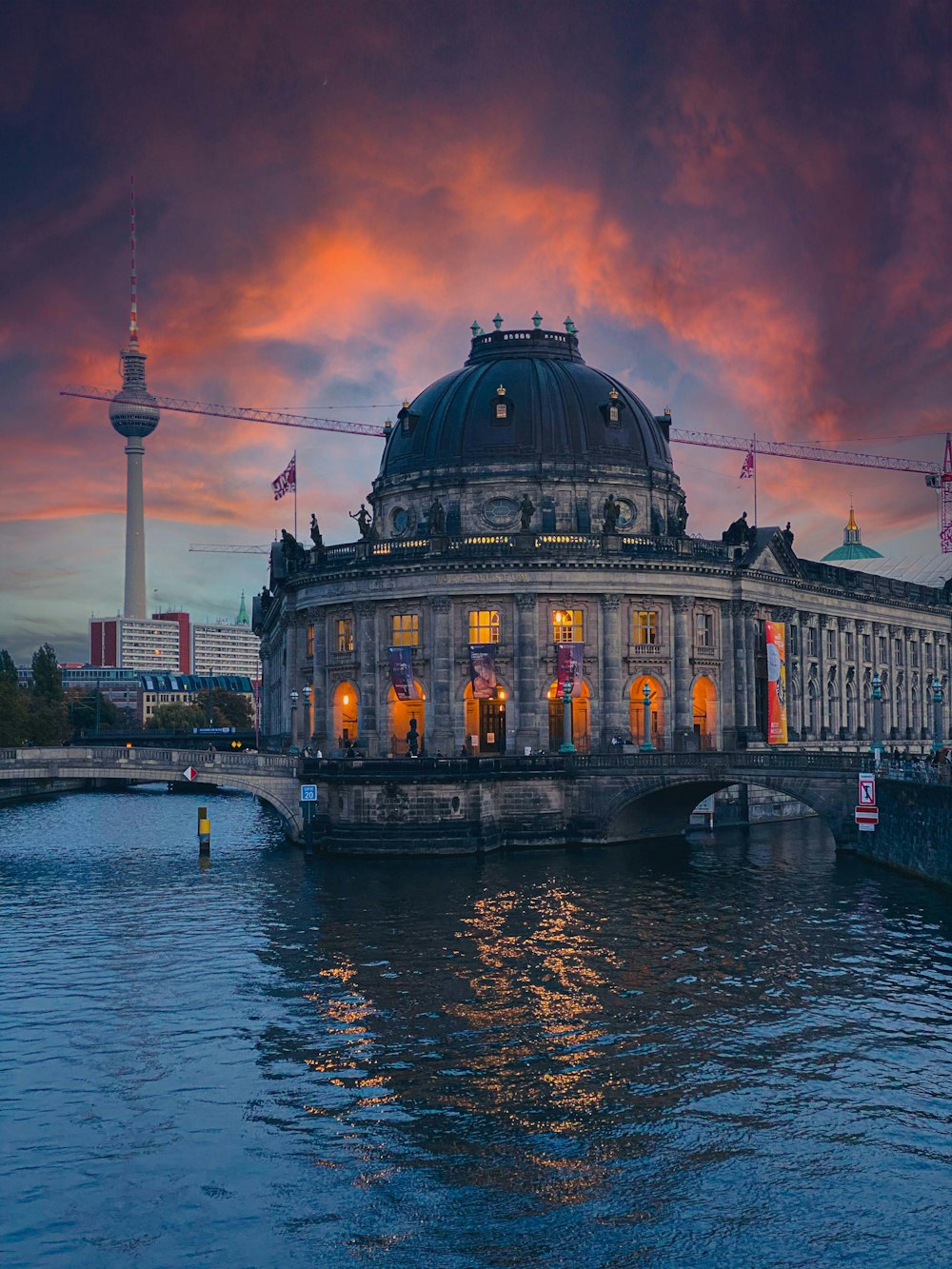 a large building sitting on top of a river next to a bridge