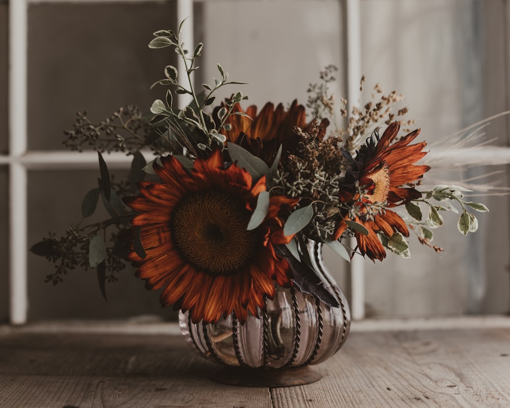 a vase filled with flowers sitting on top of a wooden table