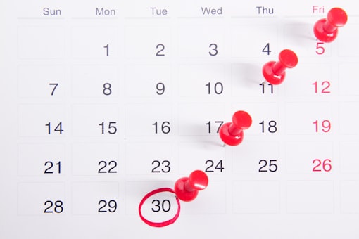 Calendário com alfinetes vermelhos marcando datas e uma delas circulada — o prazo de cancelamento da NFS-e é definido por cada município