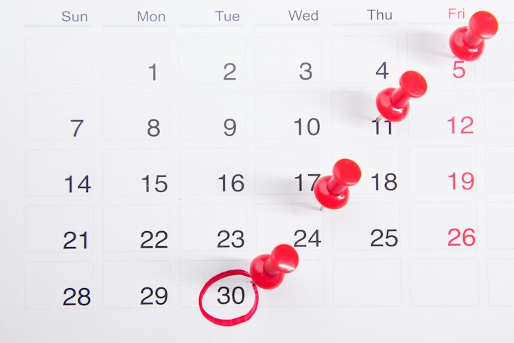 A simple calendar on a wall with a handful of days marked with checkmarks