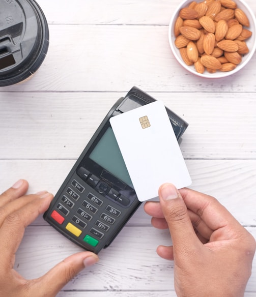 a person holding a credit card next to a calculator