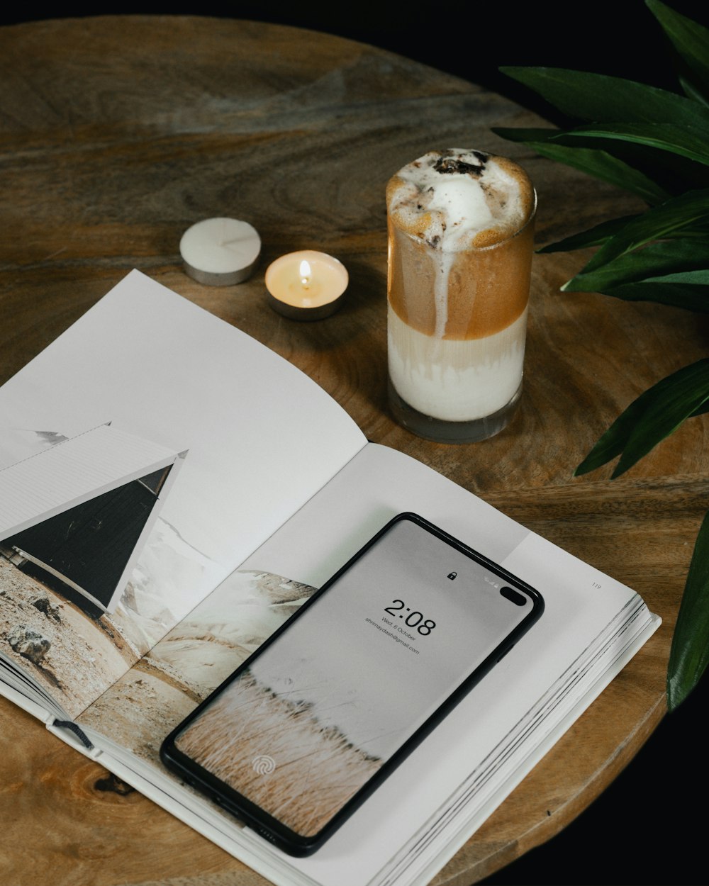 an open book on a table next to a cup of coffee