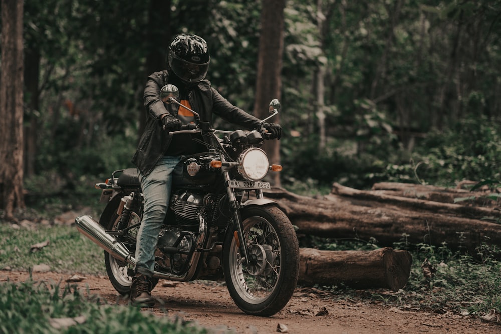a man riding on the back of a motorcycle down a dirt road
