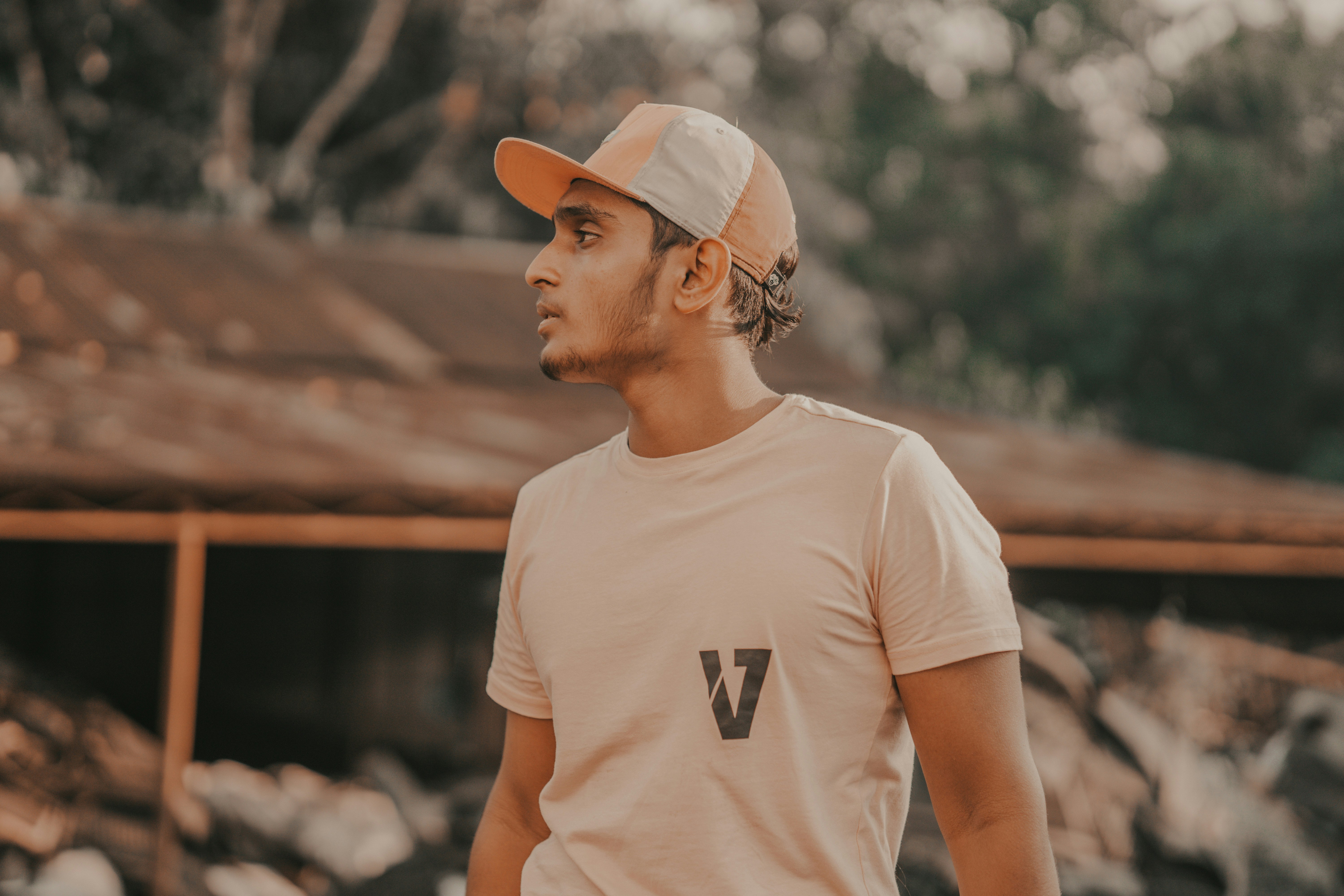 a man wearing a hat standing in front of a building