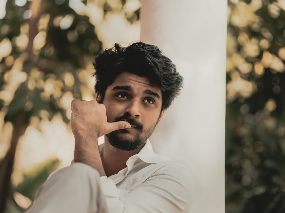 a man in a white shirt posing for a picture,