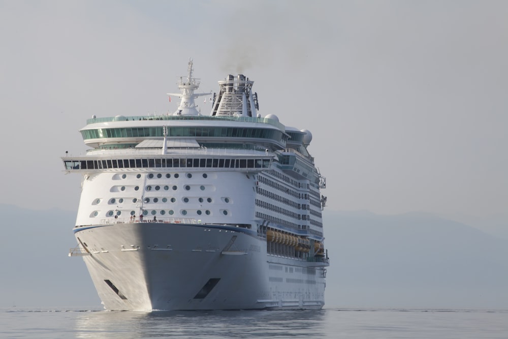 a cruise ship in the water with smoke coming out of it