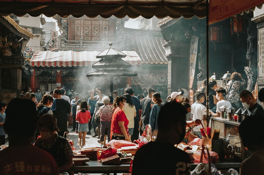 a group of people standing around a market,
