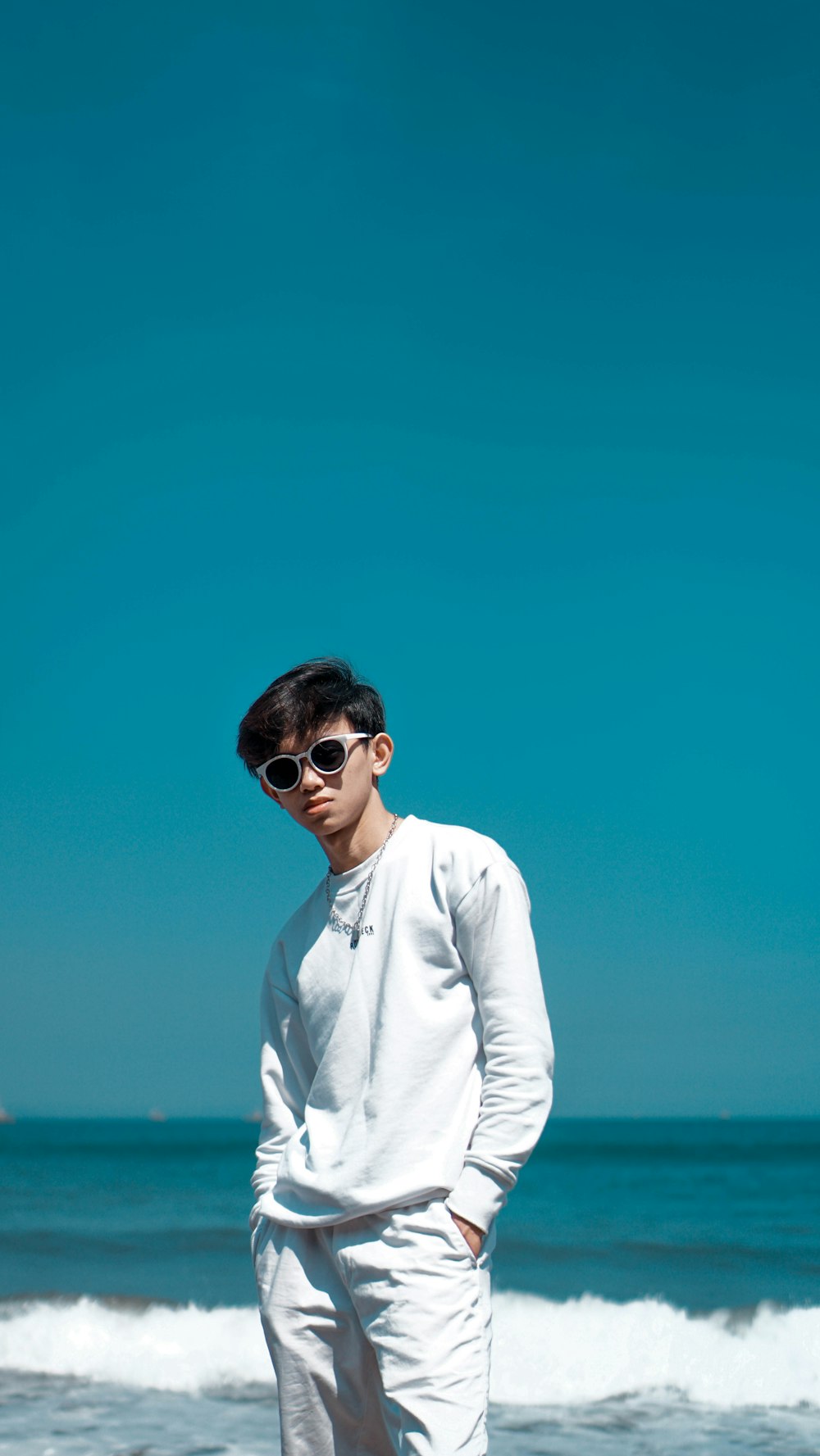 a man standing on a beach next to the ocean