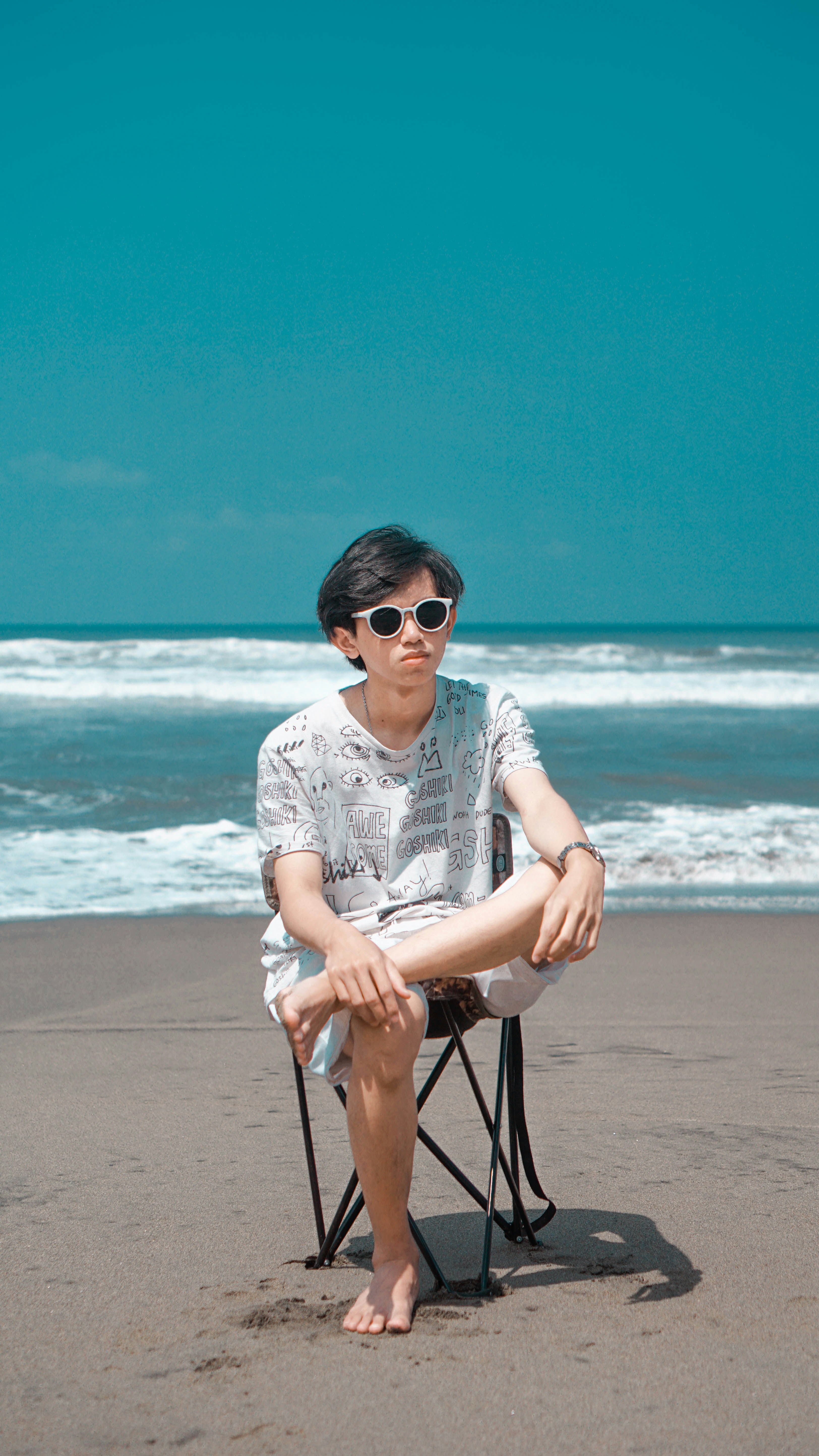 a man sitting in a chair on the beach