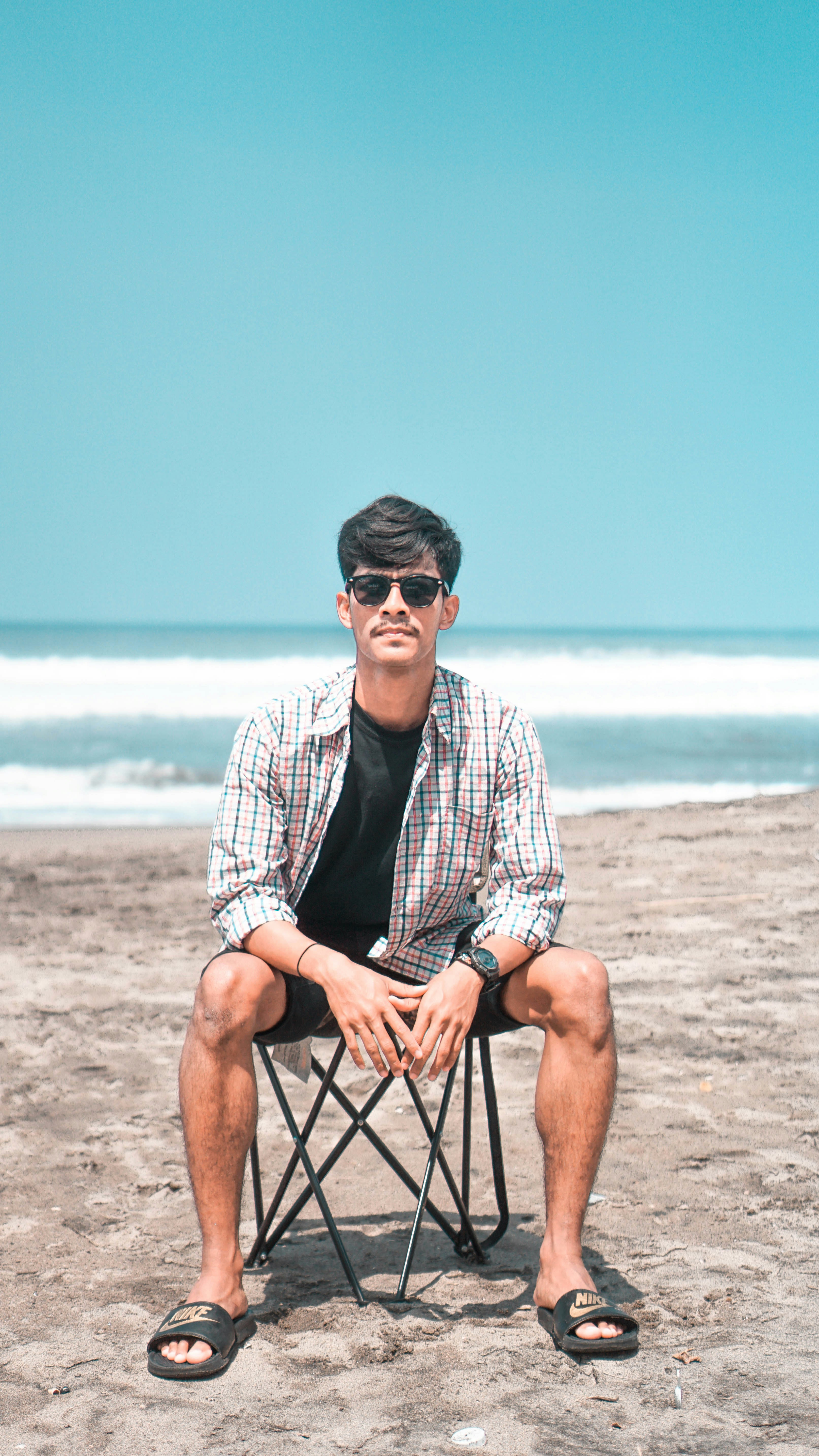 a man sitting in a chair on the beach