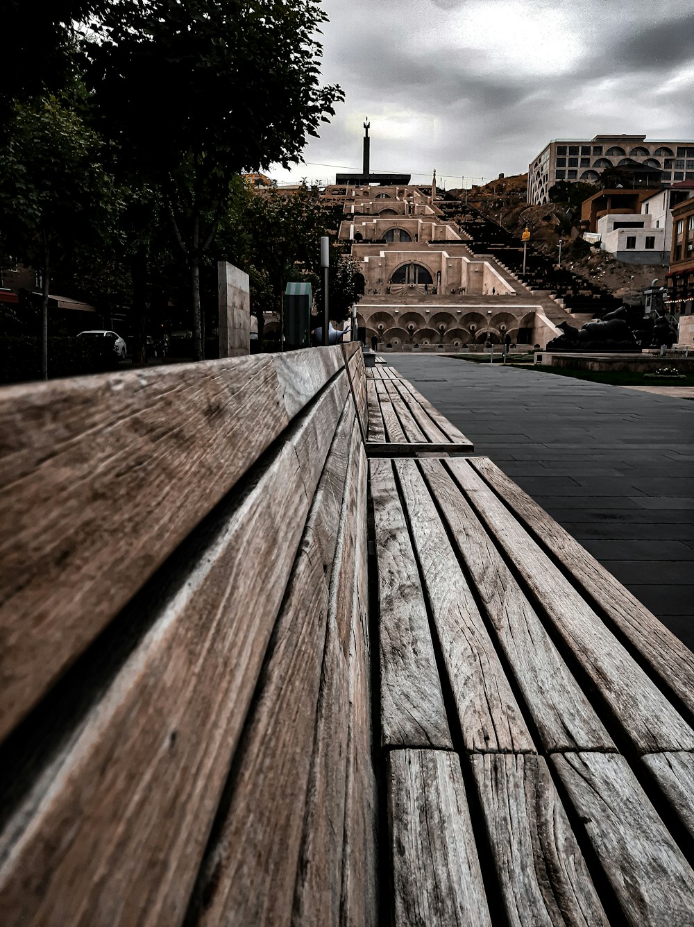 a wooden bench sitting on top of a sidewalk