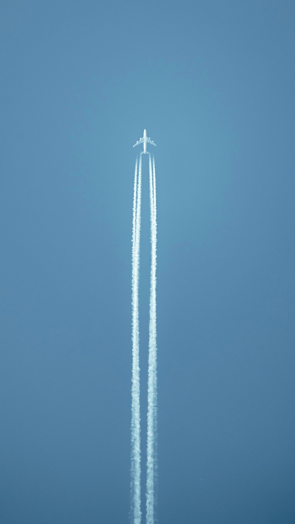 Un avión volando en el cielo dejando un rastro de humo detrás de él