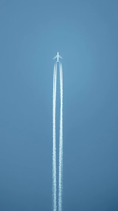 an airplane flying in the sky leaving a trail of smoke behind it