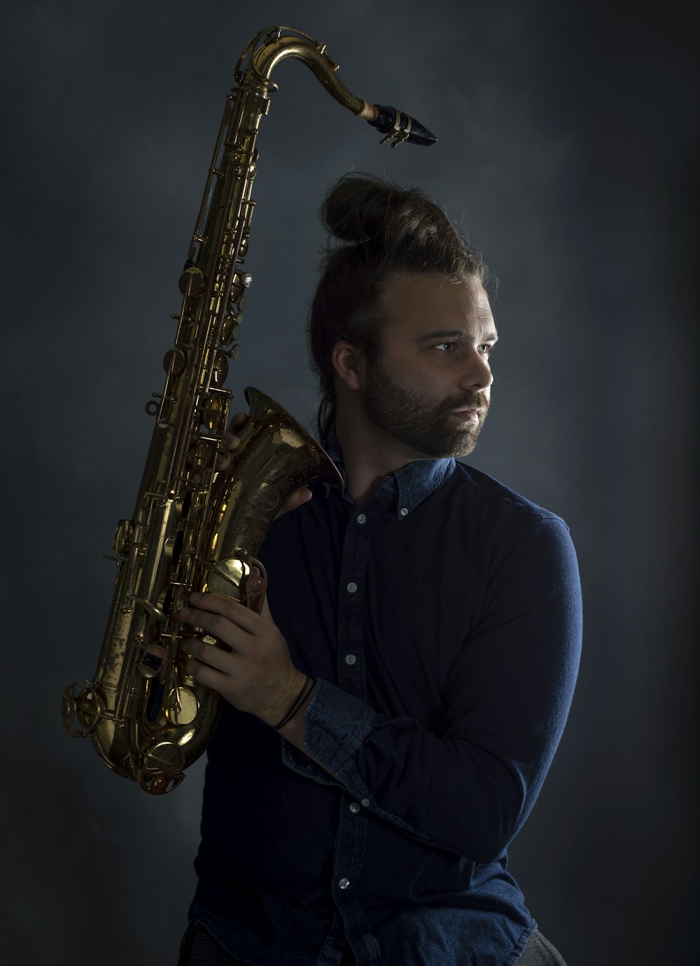 a man with a beard holding a saxophone