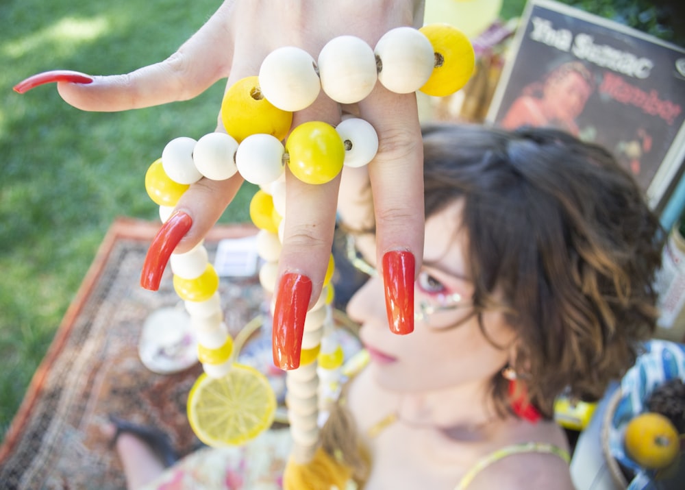 a woman holding up a bunch of fake lemons