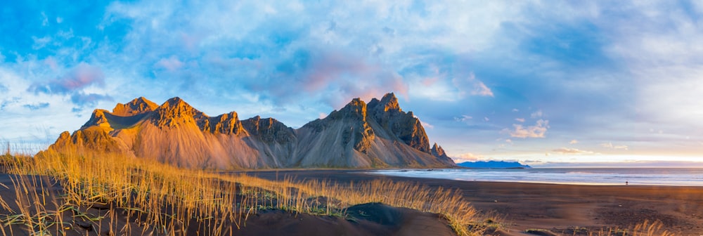 a sandy beach with a mountain in the background