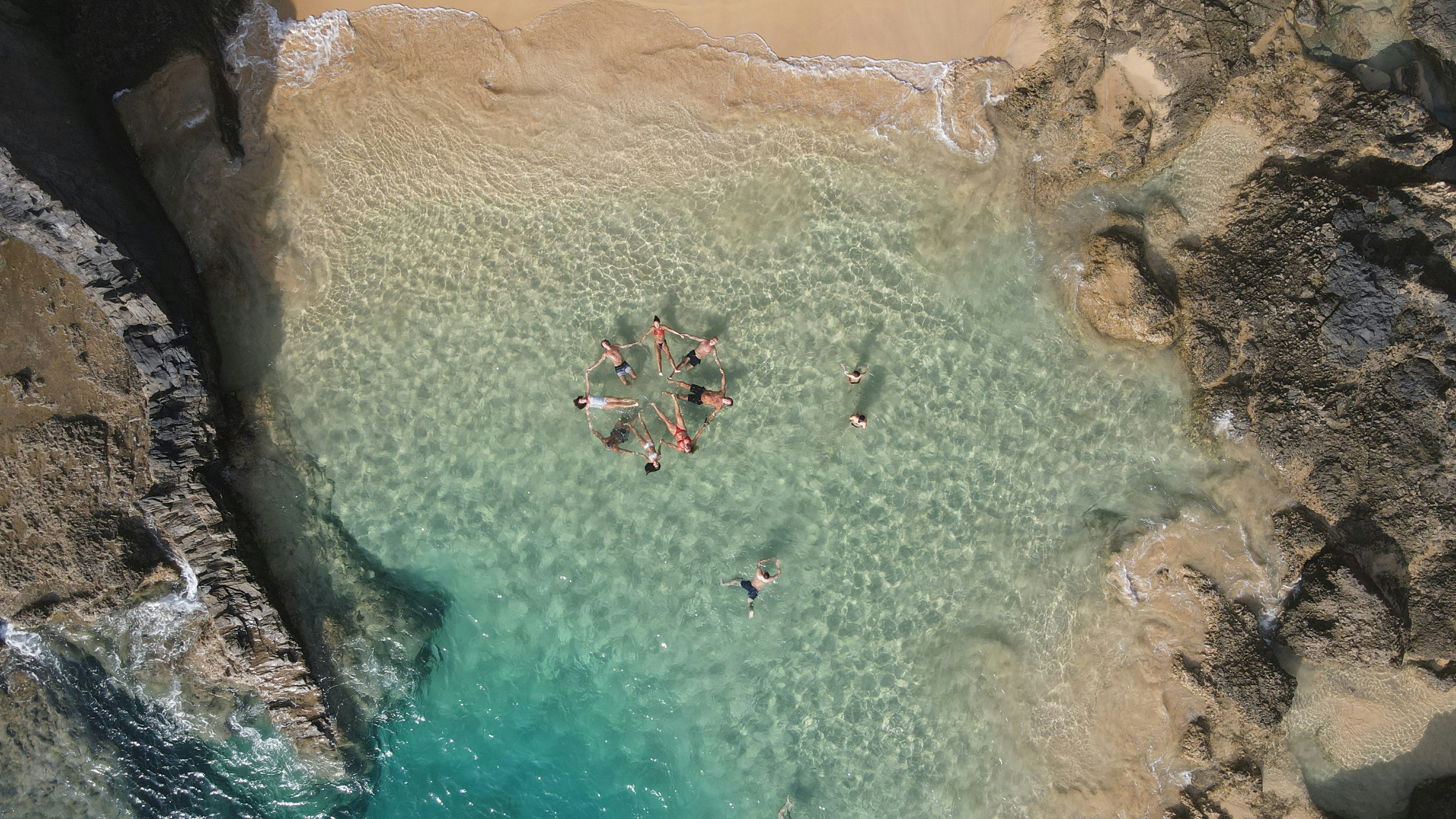 sekelompok orang berbaring di atas pantai berpasir
