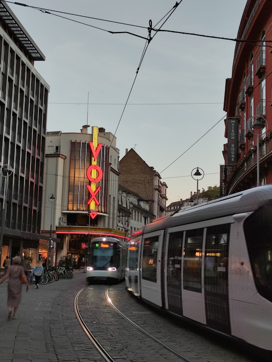 a train traveling down a street next to tall buildings