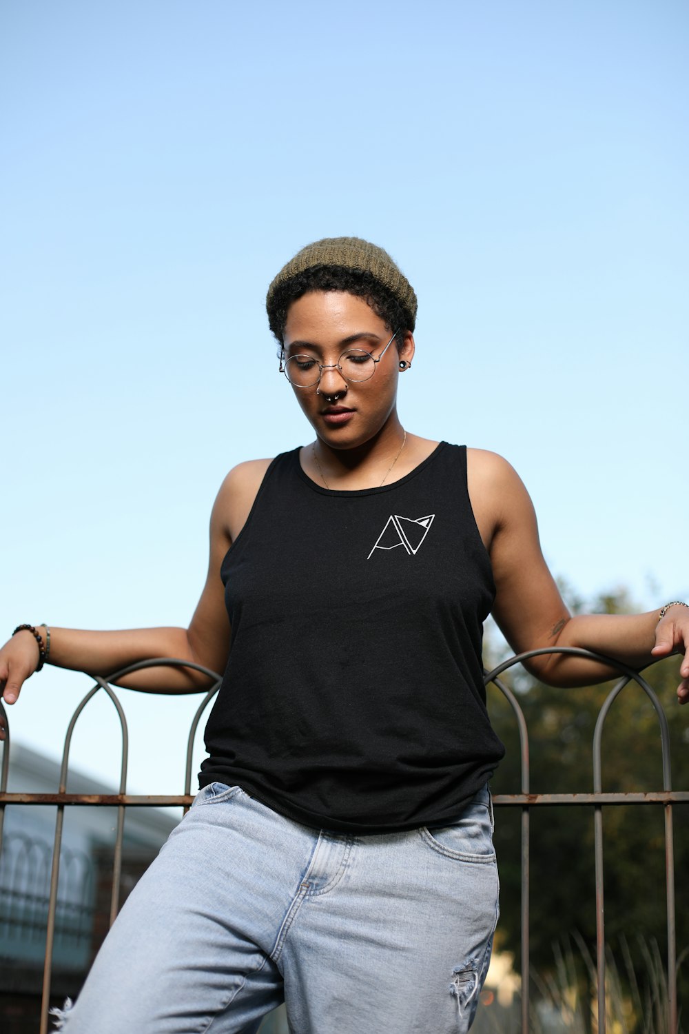 a woman leaning on a fence with her hands on her hips