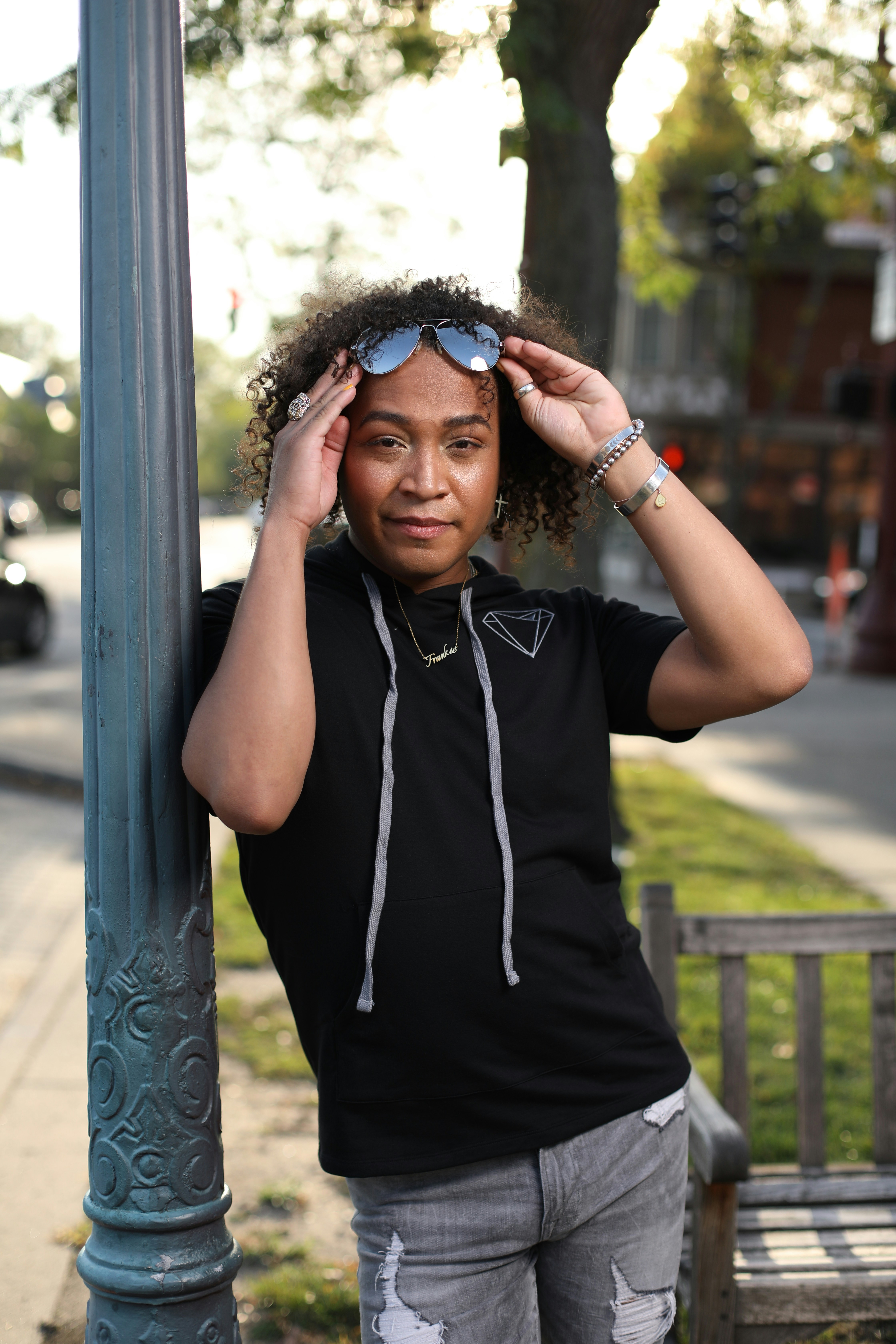 a woman leaning against a pole with her hands on her head