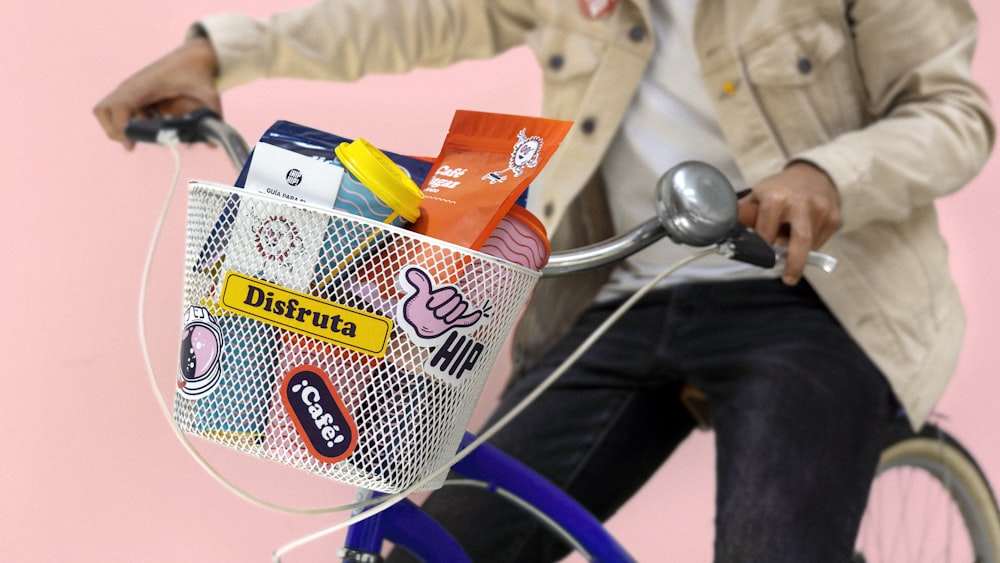 a man riding a bike with a basket full of items