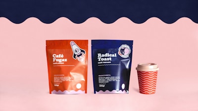 a couple of bags of coffee next to a cup