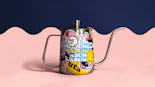 a can of beer with a handle on a pink and blue background
