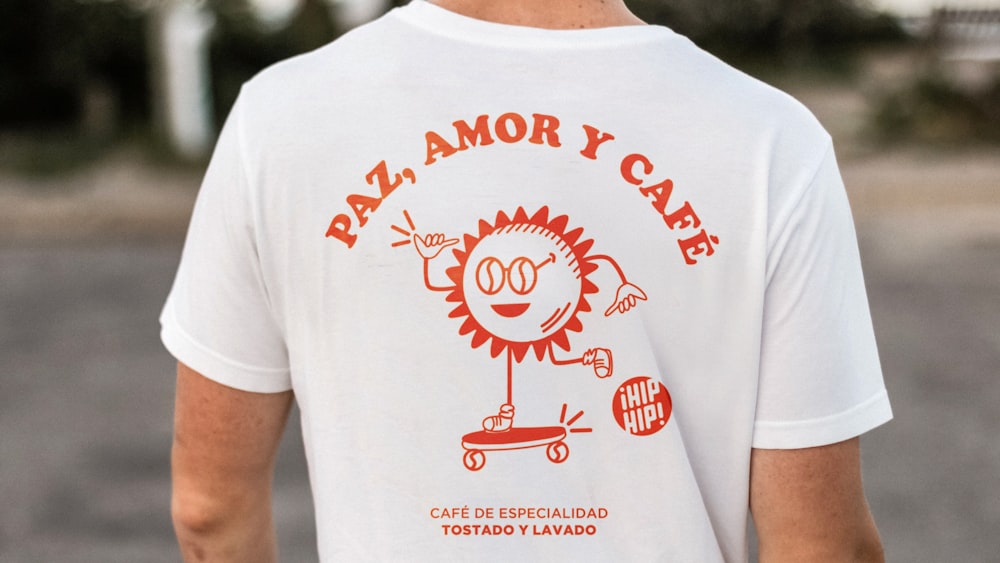 Un homme portant un T-shirt sur lequel est écrit Pat Amor y Café