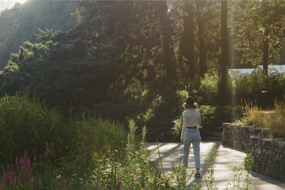 a woman walking down a path in a park