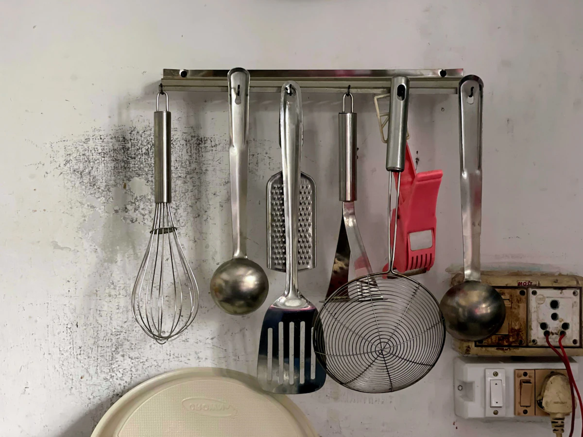 Utensils on a wall rail keeping a small kitchen counter clear