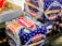 Packages of sliced bread with a blue and white design marked with the label 'Kitty Real Bake' are placed on a surface. The packaging features stars and has prominent red and green logos, alongside a 'KITTY The Master Baker' label. Part of a metal tray with residual yellow substance is visible to the side.