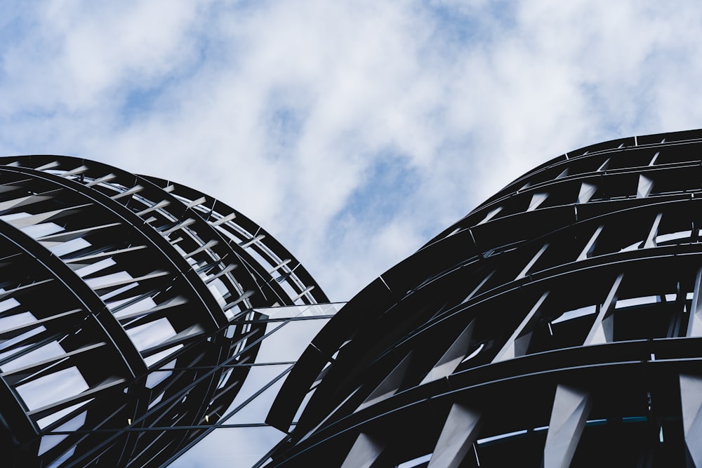 a close up of two metal structures against a cloudy sky