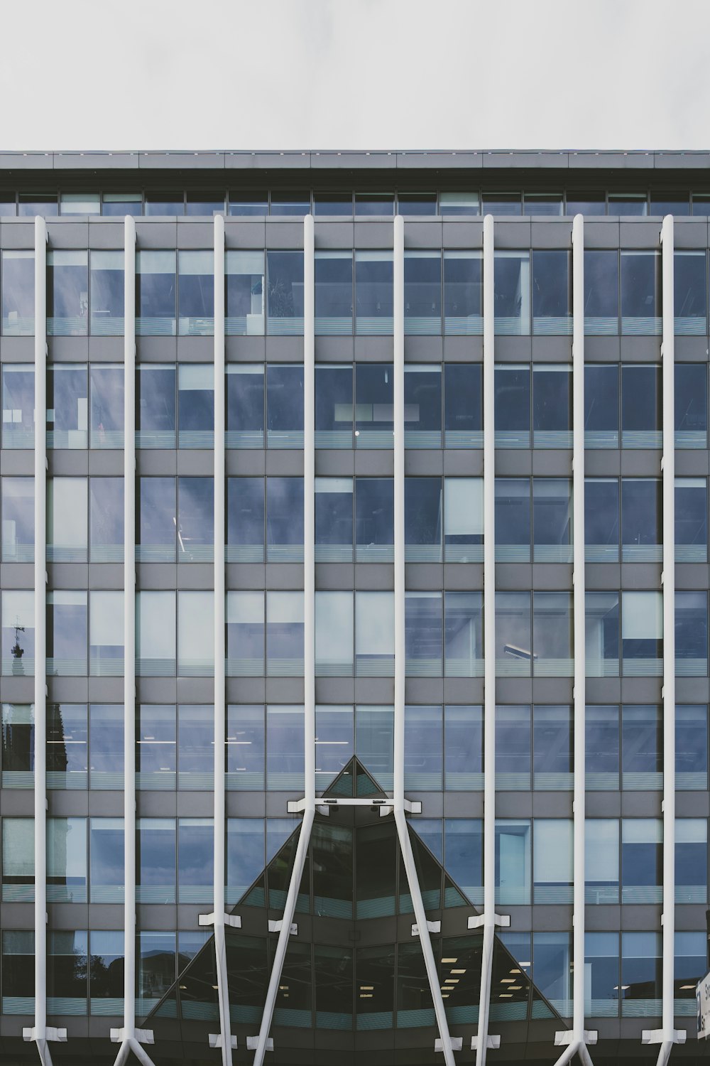 a tall building with many windows reflecting the sky