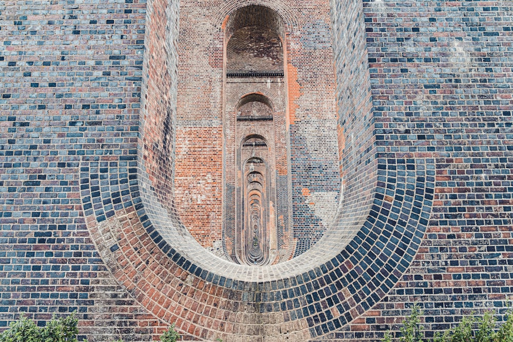 a brick wall with a window in the middle of it