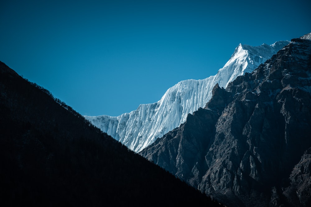 a snow covered mountain with a blue sky in the background